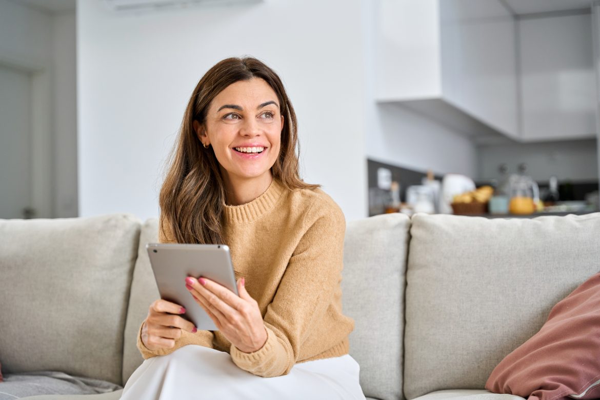 Happy,Mature,Older,Woman,Using,Digital,Tablet,Sitting,On,Couch